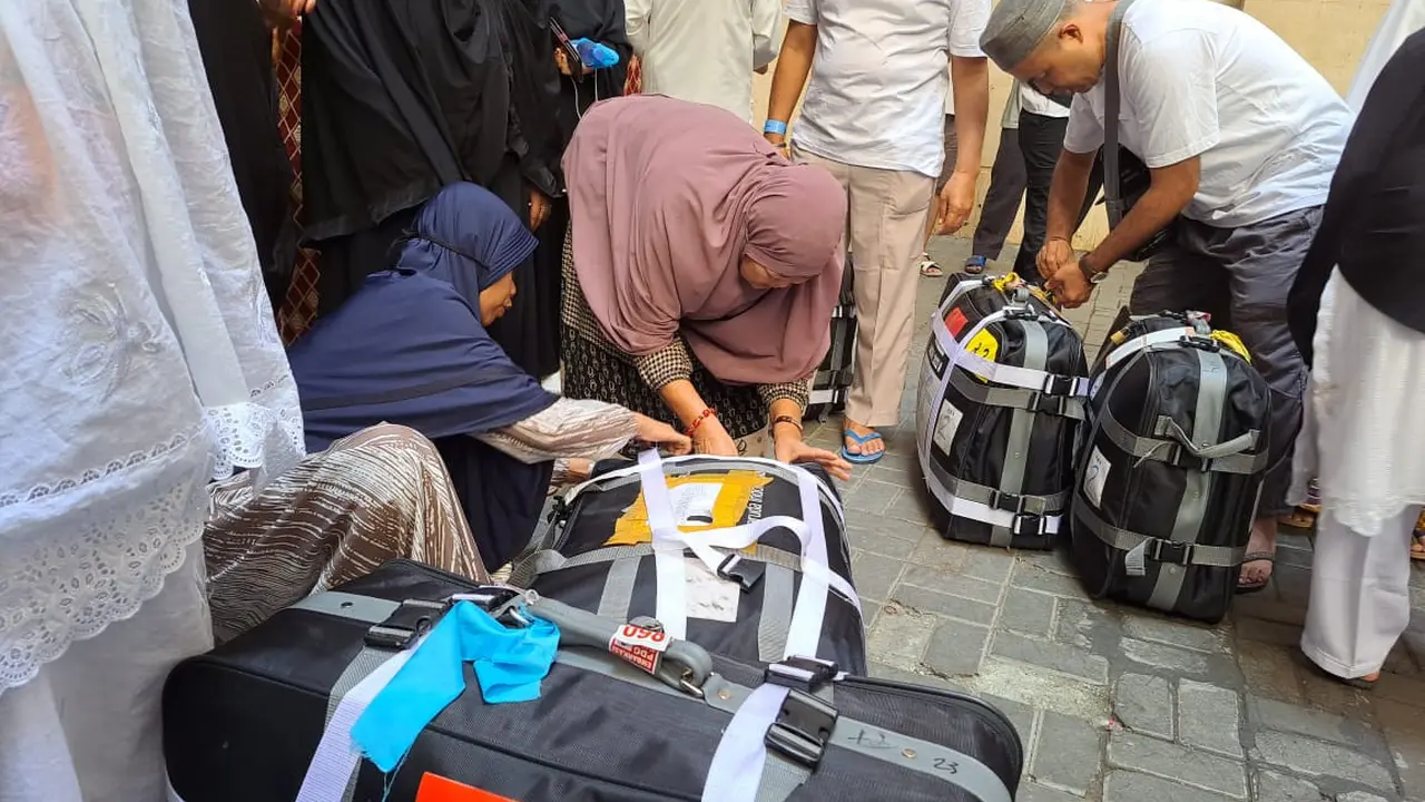 Jemaah haji dari Embarkasi PDG 2 menimbang koper, Kamis (14/7/2022) (Liputan6.com/ Mevi Linawati)