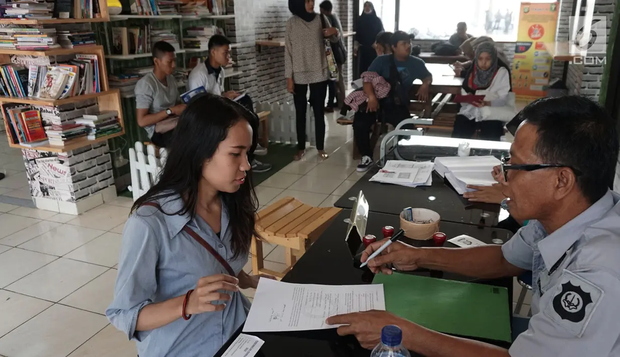 Warga sedang membuat Surat Keterangan Catatan Kepolisian (SKCK) di Mapolres Tangerang Selatan, Banten, Kamis (5/7). Mapolres Tangerang Selatan membuat perpustakaan mini untuk masyarakat yang sedang menunggu pembuatan SKCK. (Merdeka.com/Arie Basuki)