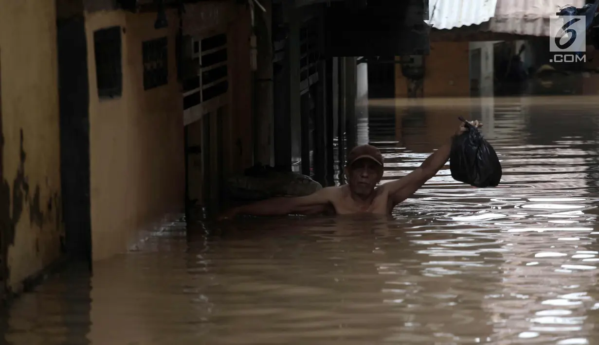 Warga melintasi banjir di Jalan Kebon Pala, Kampung Melayu, Jatinegara, Jakarta Timur, Rabu (7/2). Setelah sempat surut, banjir kembali merendam permukiman warga dengan ketinggian air mencapai sekitar 170 cm. (Liputan6.com/Arya Manggala)