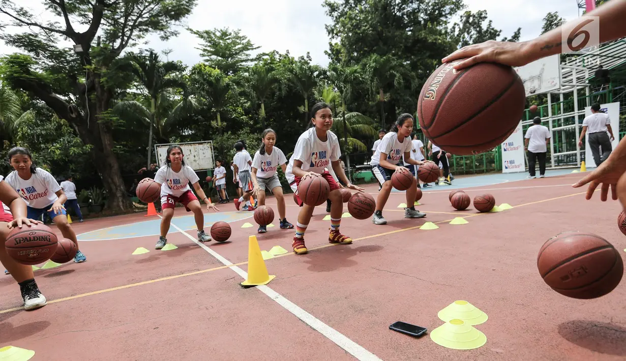 Para siswi mendribble bola pada program coaching clinic dan NBA Cares yang digelar Jr. NBA Indonesia di SMAN 82 Jakarta, Kamis (28/9). The NBA kembali menggelar program Jr. NBA, bagi pengembangan generasi muda bertaraf global yang mempromosikan gaya hidup sehat dan aktif. (Liputan6.com/Fery Pradolo)