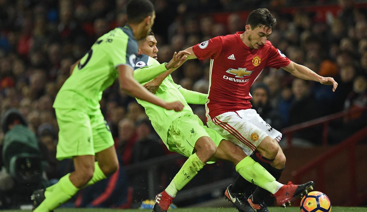 Bek Manchester United, Matteo Dramian, berusaha lepas dari hadangan gelandang Liverpool, Roberto Firmino. Perbandingan penguasaan bola kedua tim relatif berjalan seimbang, keduanya saling bertukar serangan. (AFP/Oli Scarff)