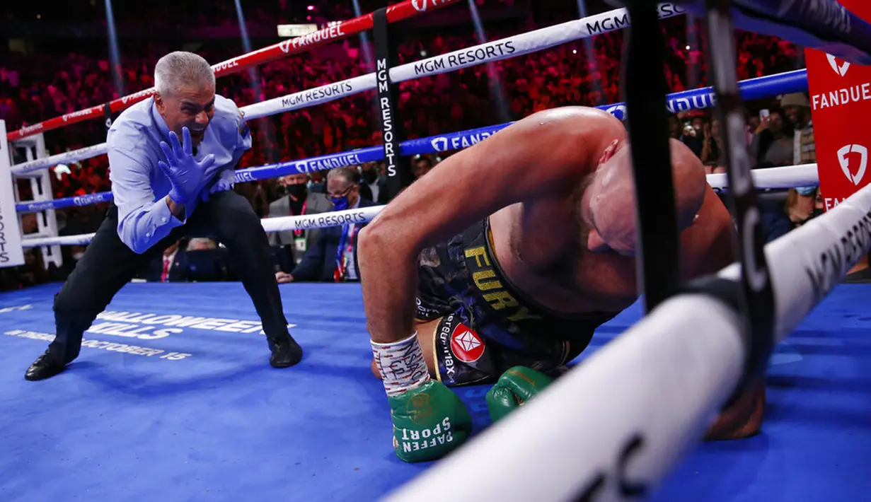 Wasit Russell Mora (kiri) menghitung saat Tyson Fury dijatuhkan oleh Deontay Wilder pada pertandingan tinju kelas berat WBC di T-Mobile Arena, Las Vegas, Nevada, Amerika Serikat, 9 Oktober 2021. Tyson Fury mengalahkan Deontay Wilder pada ronde ke-11. (AP Photo/Chase Stevens)