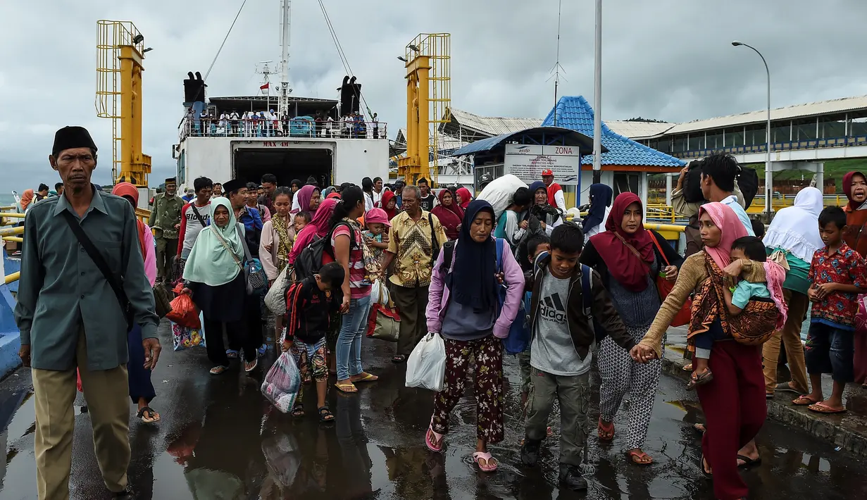 Para pengungsi turun dari kapal ferry usai dievakuasi dari Pulau Sebesi, di Pelabuhan Bakauheni, Lampung, Rabu (26/12). Ribuan pengungsi tsunami dari Pula Sebesi terpaksa dievakuasi menggunakan kapal ferry. (AFP Photo/Mohd Rasfan)