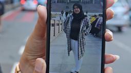 Pihak keluarga menunjukan foto anggota saat menunggu kepulangan WNI yang sudah selesai menjalani observasi di Natuna, di Bandara Halim Perdana Kusuma, Jakarta, Sabtu (15/2/2020). Pemerintah resmi memulangkan 238 WNI ke daerah masing-masing karena telah dinyatakan sehat (Liputan6.com/Herman Zakharia)