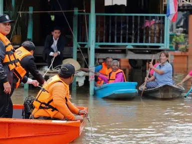 Perdana Menteri Thailand Prayuth Chan-ocha bersama tim SAR saat meninjau warga yang terjebak banjir di Distrik Sena, Ayutthaya, Thailand (5/10). Thailand mengatakan sekitar 96.000 hektare terendam dan banyak akses terputus.( Reuters/Chaiwat Subprasom)