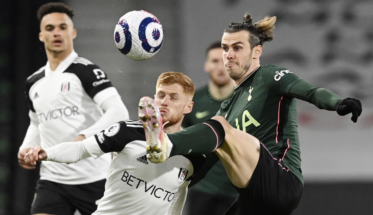 Penyerang Tottenham Hotspur, Gareth Bale, berebut bola dengan pemain Fulham, Harrison Reed, pada laga Liga Inggris di Stadion Craven Cottage, Kamis (4/3/2021). Tottenham Hotspur menang dengan skor 1-0. (Neil Hall/Pool via AP)