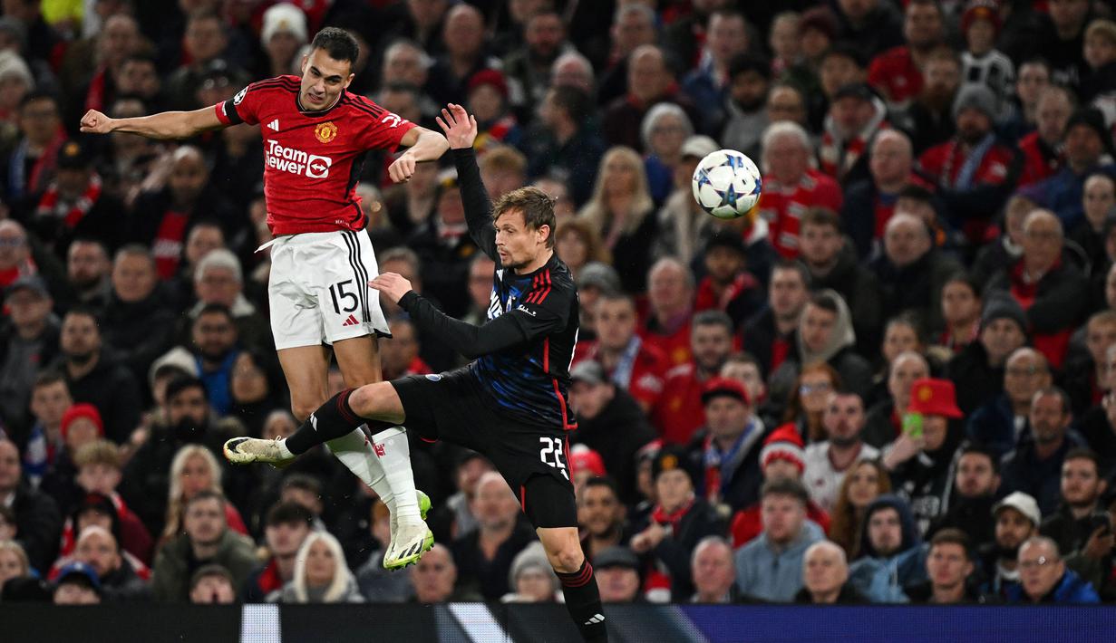 Pemain Manchester United, Sergio Reguilon (kiri) berduel udara dengan pemain FC Copenhagen, Peter Ankersen pada laga Grup A Liga Champions 2023/2024 di Old Trafford, Manchester, Inggris, 24 Oktober 2023. (AFP/Paul Ellis)