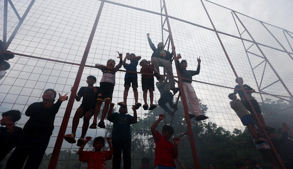 Suporter fanatik klub kota Jakarta itu meminta skuad Macan Kemayoran mampu mengalahkan Maung Bandung di laga lanjutan BRI Super League. Tampak dalam foto, pendukung Persija Jakarta atau The Jakmania memanjat pagar pembatas Persija Training Ground, Bojong Sari, Depok, Jawa Barat, Jumat (9/1/2026). (Bola.com/M Iqbal Ichsan)
