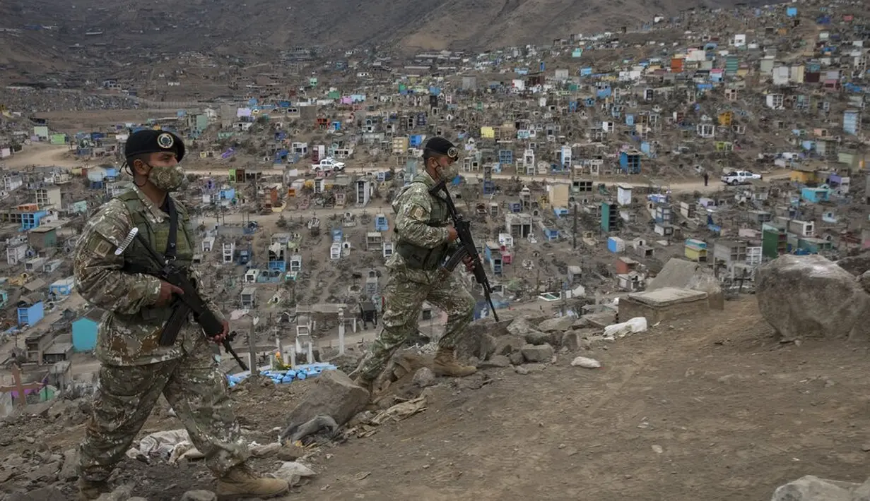 Tentara berpatroli di salah satu pintu masuk Pemakaman Nueva Esperanza, Lima, Peru, Minggu (1/11/2020). Untuk membantu mencegah penyebaran COVID-19, pihak berwenang menutup semua pemakaman secara nasional selama perayaan Day of the Dead. (AP Photo/Rodrigo Abd)