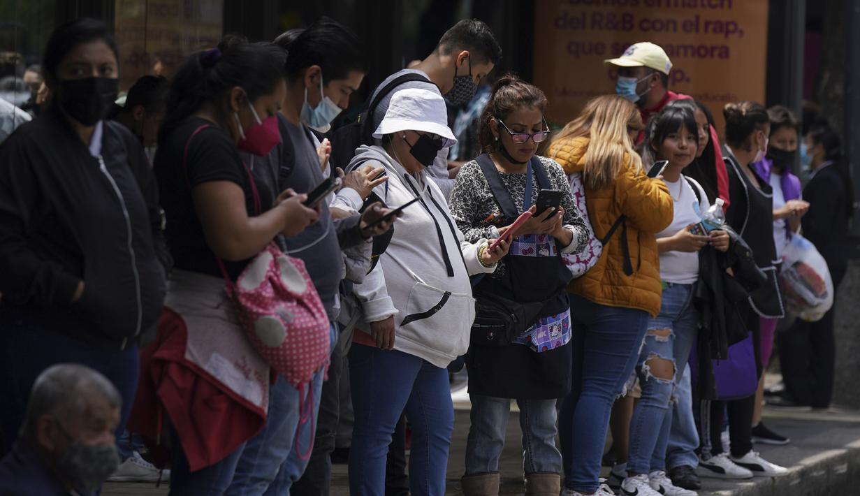 Orang-orang berkumpul di luar halte bus setelah gempa berkekuatan gempa bumi bermagnitudo 7,6 dirasakan di Mexico City, Senin (19/9/2022). Presiden Andres Manuel Lopez Obrador mengatakan dalam sebuah pidato video bahwa seseorang telah meninggal di pelabuhan Pasifik Manzanillo, setelah sebuah dinding runtuh di sebuah toko. (AP Photo/Fernando Llano)