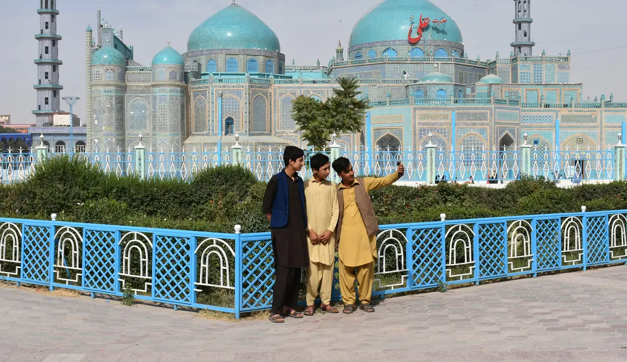 Orang-orang berswafoto di depan Masjid Biru di Mazar-i-Sharif, ibu kota Provinsi Balkh, Afghanistan utara 11/7/2020). Setelah lima bulan ditutup akibat dampak pandemi COVID-19, Masjid Biru baru-baru ini telah dibuka kembali untuk umum. (Xinhua/Kawa Basharat)