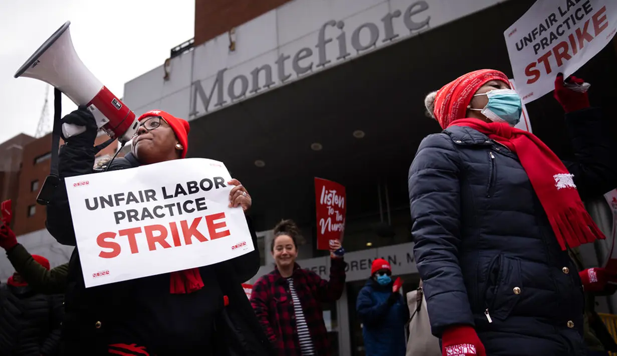 Para pengunjuk rasa berbaris saat melakukan aksi mogok kerja di jalan sekitar Montefiore Medical Center, Bronx, New York, Amerika Serikat, 11 Januari 2023. Aksi mogok kerja yang berlangsung sejak 9 Januari 2023 ini dilakukan setelah negosiasi kontrak mengenai menaikan upah dan kepegawaian mengalami jalan buntu. (AP Photo/John Minchillo)