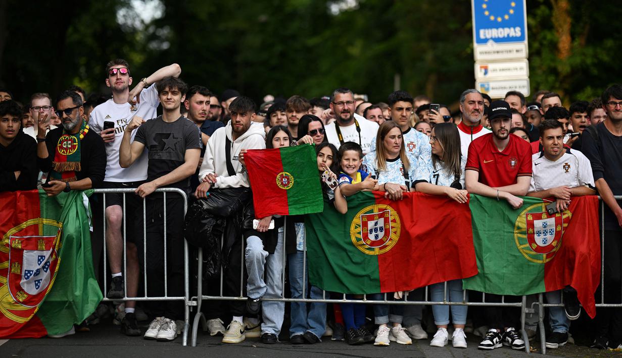 Sejumlah fans menyambut kedatangan Timnas Portugal di hotel tempat menginap jelang Euro 2024 di Harsewinkel, Jerman, Rabu (13/06/2024) waktu setempat. (AFP/Patricia De Melo Moreira)