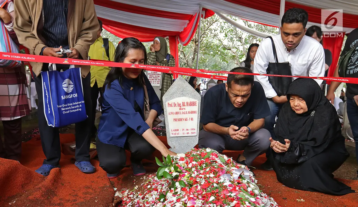 Warga membaca doa di depan makam Presiden ketiga RI BJ Habibie di TMP Kalibata, Jakarta, Kamis (12/9/2019). Tidak hanya dihadiri tokoh-tokoh penting, ratusan warga juga antusias datang ke TMP Kalibata untuk mengantarkan BJ Habibie ke tempat peristirahatan terakhirnya. (Liputan6.com/Herman Zakharia)