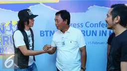 Direktur Bank BTN Sis Apik Wijayanto (tengah) berjabat tangan dengan Bimbim Slank usai jumpa pers BTN di markas Slank, Jakarta, Senin (15/02/2016). BTN menggelar Homerun in Harmony bersama Slank untuk merayakan HUT ke-60 (Liputan6.com/Herman Zakharia)