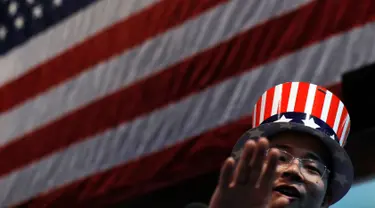 Seorang pria mengenakan topi bermotif bendera Amerika Serikat saat menonton siaran langsung pemilihan presiden AS yang digelar di Kedutaan Besar AS di Beijing, Rabu (9/11). (AP Photo / Andy Wong)