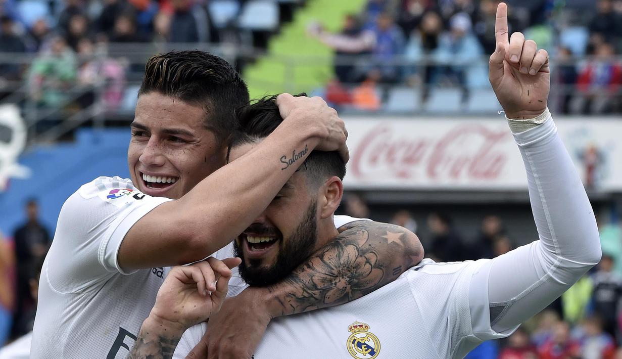 Pemain Real Madrid, Isco (kanan) merayakan golnya bersama James Rodriguez saat melawan Getafe  pada lanjutan La Liga Spanyol di Stadion Colisseum Alfonso Perez, Getafe, Sabtu (16/4/2016) malam WIB. (AFP/Gerard Julien)