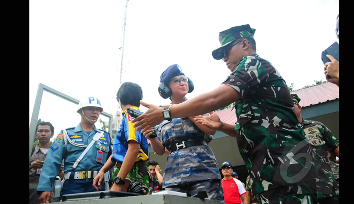 Salah satu anggota TNI AL memberikan pelatihan singkat pada pedangdut Dewi Perssik di Lapangan Tembak Mabesal, Cilangkap, Jakarta, Jumat (27/2/2015). (Liputan6.com/Yoppy Renato)