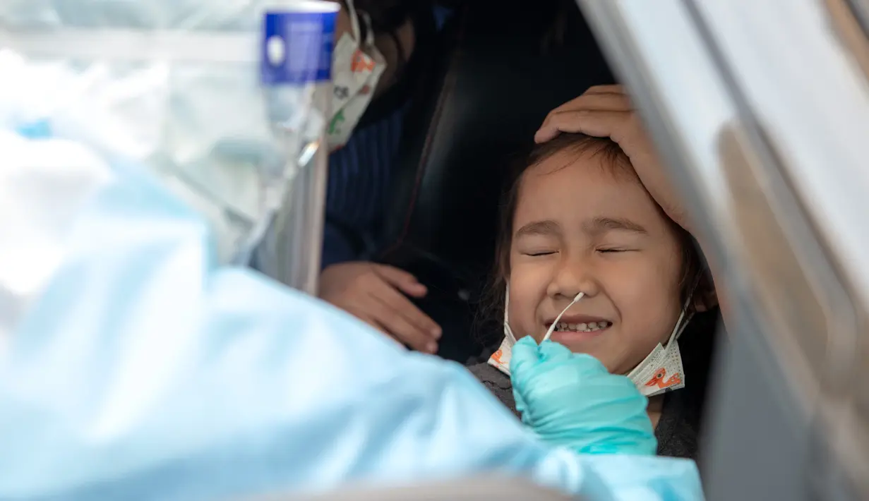 Staf medis mengambil sampel usap (swab) anak kecil yang berada di dalam kendaraan untuk tes COVID-19 di Shah Alam, Negara Bagian Selangor, Malaysia (12/12/2020). Malaysia melaporkan 1.937 kasus baru COVID-19, menambah total kasus di negara tersebut menjadi 82.246. (Xinhua/Chong Voon Chung)