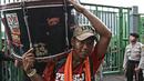 Seorang The Jakmania memikul gendang kedalam stadion untuk mengiringi nyanyian rekan-rekannya di Stadion Patriot, Bekasi, Kamis (4/5/2017). The Jakmania hadir untuk mendukung Persija Jakarta melawan Madura United. (Bola.com/Nicklas Hanoatubun)