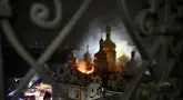 Asap dan api membubung dari Katedral Dormition, kompleks Ortodoks Kyiv Pechersk Lavra setelah serangan rudal Rusia di ibu kota Ukraina, Kyiv, Senin 15 Juni 2026, di tengah invasi Rusia. (Genya Savilov/AFP)
