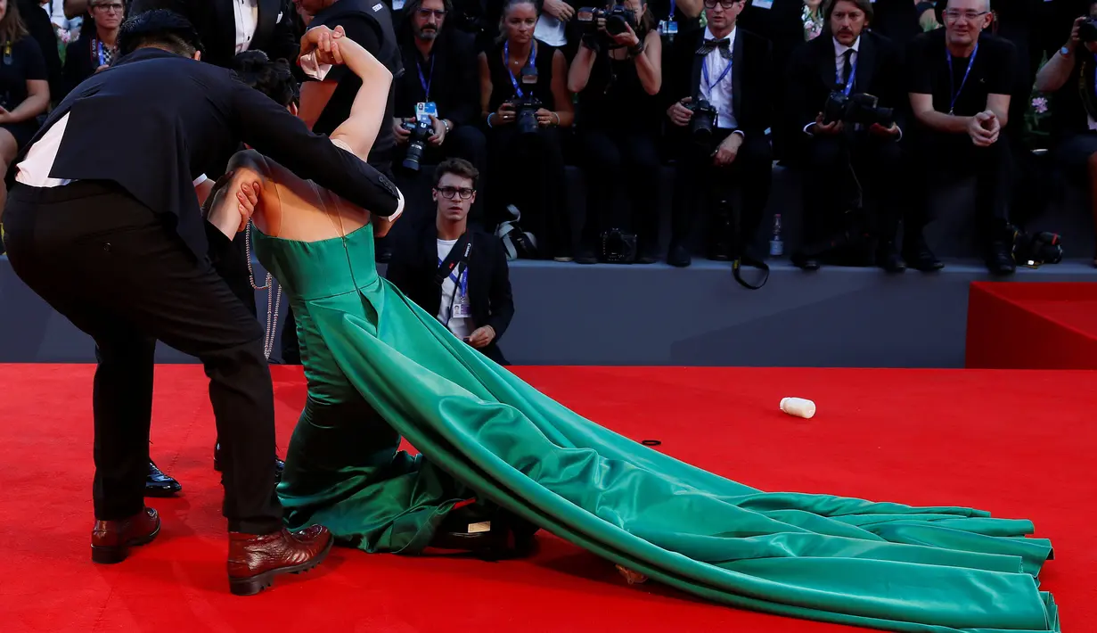 Aktris Korsel, Moon So-ri jatuh mendarat dengan tumpuan kedua lututnya ketika melenggang di karpet merah pemutaran perdana film The Light Between Two Ocean di Venice Film Festival, Italia, Kamis (1/9). (REUTERS/Alessandro Bianchi)