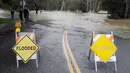 Papan pemberitahuan meluapnya Sungai Coyote Creek terpasang di Morgan Hill, California, Selasa (21/2). Sungai Coyote Creek yang tidak mampu menampung debit air setelah hujan lebat mengakibatkan California terendam banjir. (AP Photo/Marcio Jose Sanchez)
