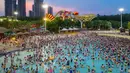 Pengunjung bersantai sambil mendinginkan diri di kolam renang di Wuhan rovinsi Hubei, China pada 27 Juli 2019. Cuaca yang cukup panas membuat mereka berbondong-bondong menyesaki kolam renang. (Photo by - / AFP)