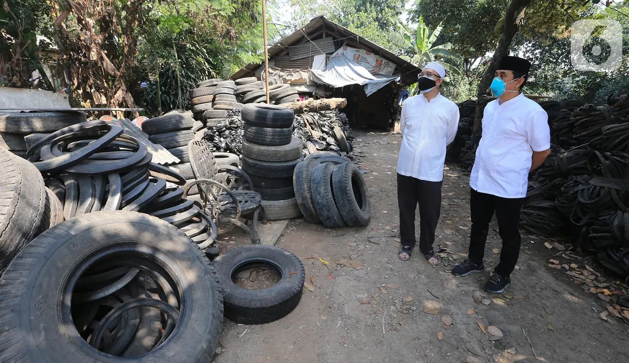 Anggota Komisi XI DPR RI Kamrussamad bersama warga saat melihat ban bekas yang akan diproduksi untuk UMKM di Juanda Depok, Jawa Barat, Selasa (20/7/2021). Pada penerapan kebijakan PPKM Darurat, Kamrussamad berharap terus mendorong usaha kecil di masa pandemi. (Liputan6.com/HO/Bon)