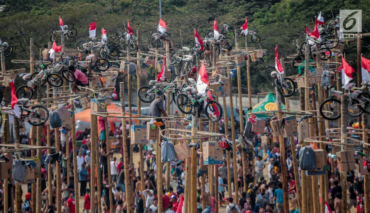 Warga mengikuti lomba Panjat Pinang Kolosal dalam rangka merayakan HUT ke-74 Kemerdekaan RI di Pantai Karnaval Ancol, Jakarta, Senin (17/8/2019). Sebanyak 174 batang pinang dengan beragam hadiah disediakan dalam lomba yang diikuti ratusan warga itu. (Liputan6.com/Faizal Fanani)