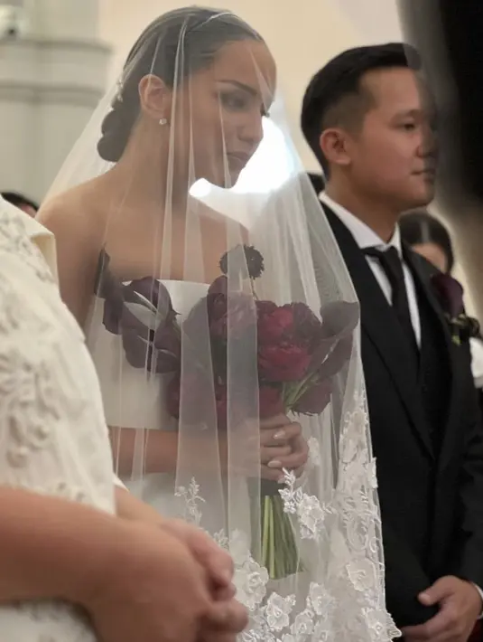 <p>Angel terlihat menghiasi tampilannya dengan anting-anting minimalis namun mewah. Ia pun membawa bouket bunga mawar.&nbsp;</p>