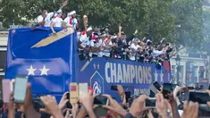Timnas Prancis mengikuti pawai dengan bus atap terbuka merayakan juara Piala Dunia 2018 di sepanjang Champs Elysees, Paris, Senin (16/7). Prancis menggelar pesta besar penyambutan sekaligus parade kemenangan bagi skuad ”Les Bleus”. (AP/Claude Paris)