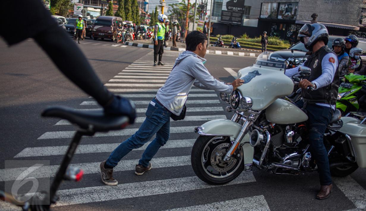 Andika Faizal (19 tahun), mendorong sebuah motor peserta Jogja Bike Rendevouz 2015 dari zebra cross di perempatan Ringroad Utara Condongcatur, Sleman, Yogyakarta, Sabtu (15/08/2015). (foto: Suryo Wibowo)