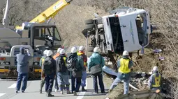 Bangkai bus yang tergelincir diangkat menggunakan alat berat di Karuizawa, prefektur Nagano, Jepang, Jumat (15/1). Bus yang membawa pengunjung resor ski tersebut tergelincir dan menewaskan 14 orang serta melukai 27 lainnya. (REUTERS/Kyodo)