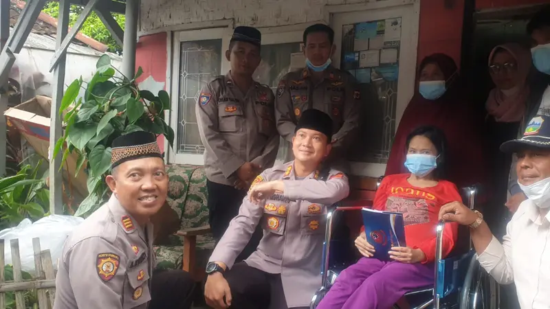 Kapolres Garut AKBP Wirdhanto Hadicaksono, menyerahkan satu unit kursi roda dan uang 'kadeudeuh' dalam program rutin 'Jumat Berkah' polres Garut. (Liputan6.com/Jayadi Supriadin)