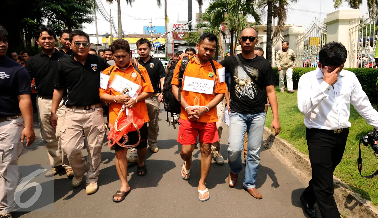 Petugas menggiring tersangka kasus perampokan disertai penyanderaan untuk melakukan rekonstruksi kejadian di Jalan Metro Hijau IX, Jakarta, Selasa (13/9). 60 adegan reka ulang kejadian diperagakan tersangka. (Liputan6.com/Helmi Fithriansyah)