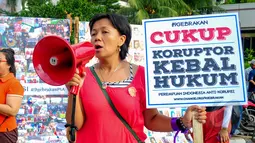 Seorang aktivis Perempuan Indonesia Antikorupsi berorasi saat menggelar aksi menolak korupsi di Bundaran HI, Jakarta, Minggu (8/3/2015). Mereka juga meminta Presiden Jokowi tegas dalam memberantas korupsi di Indonesia. (Liputan6.com/Yoppy Renato) 