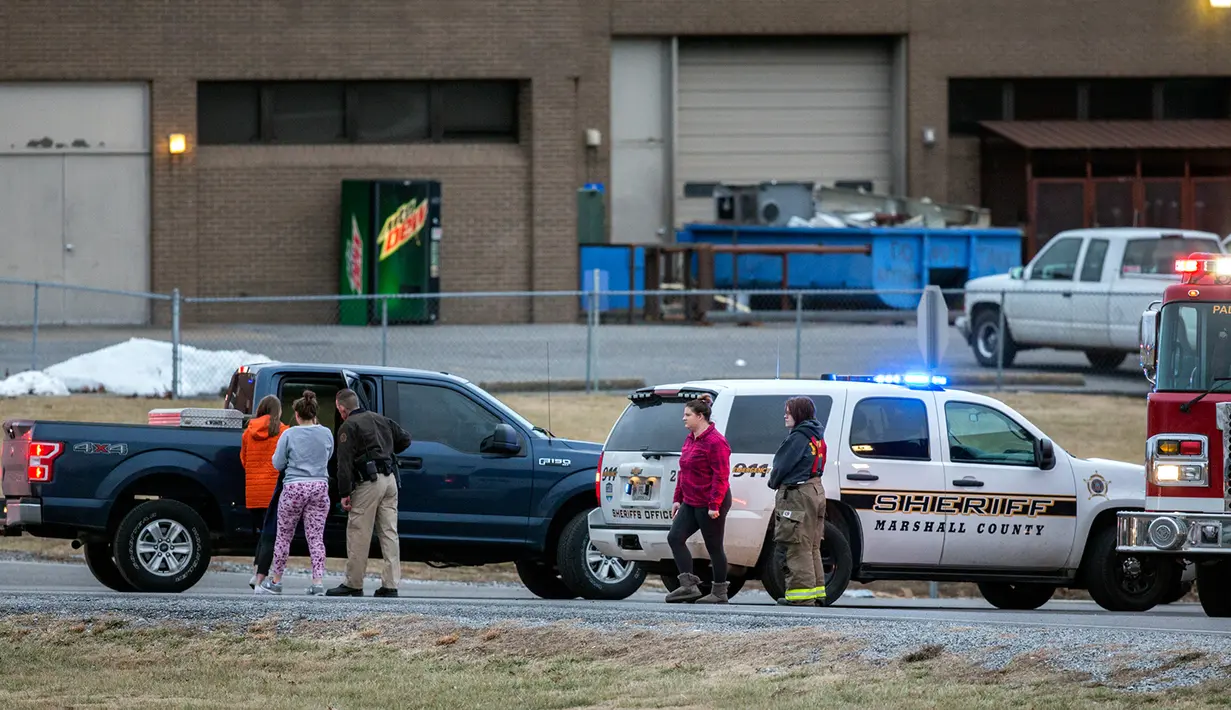 Polisi mengawal siswa SMA Marshall County High School untuk mengambil kendaraan mereka pascapenembakan mematikan di Benton, Kentucky, Amerika Serikat, Selasa (23/1). (Ryan Hermens/The Paducah Sun via AP)
