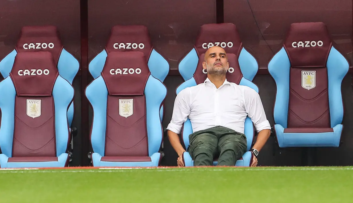 Pelatih Manchester City, Pep Guardiola duduk santai di bangku cadangan saat memantau latihan ringan sebelum laga Aston Villa melawan Manchester City di pekan keenam Liga Inggris 2022/2023. (AFP/Geoff Caddick)
