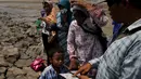Warga menjajakan kaset video lumpur kepada wisatawan yang mengunjungi lumpur Lapindo di Sidoarjo, Jawa Timur, 11 Oktober 2015. Beberapa tahun silam, Porong didera bencana, namun kini kawasan tersebut menjadi objek wisata tak biasa. (REUTERS/Beawiharta)