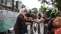 Dibantu beberapa staf kejaksaan, Kajari Garut, Neva Sari Susanti langsung memimpin pembagian paket takjil ramadan 2022 kepada pengguna jalan di depan kantor Kejari Garut, Senin petang. (Liputan6.com/Jayadi Supriadin)