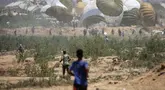 Warga Palestina bergegas menuju lokasi pendaratan paket bantuan yang diterjunkan di wilayah Nuseirat, Jalur Gaza tengah, saat penerjunan bantuan dari udara di atas wilayah Palestina yang dikepung Israel pada 6 Agustus 2025. (Eyad BABA/AFP)
