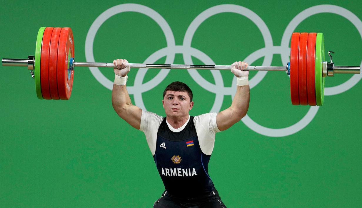 Atlet angkat besi Armenia, Andranik Karapetyan tampil mengangkat beban di nomor 77 kg putra pada Olimpiade 2016 di Rio de Janeiro, Rabu (10/8). Saat Karapetyan mengangkat bebannya di atas kepala, siku tangan kirinya tiba-tiba patah. (REUTERS/Stoyan Nenov)