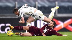 Bek Juventus, Matthijs de Ligt, terjatuh saat berebut bola dengan pemain Torino, Karlol Linetty, pada laga Liga Italia di Stadion Allianz, Minggu (6/12/2020). Juventus menang dengan skor 2-1. (Fabio Ferrari/LaPresse via AP)