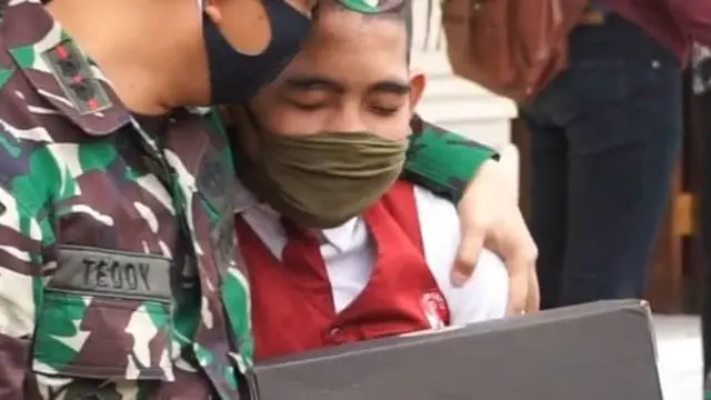 Letkol HTL saat pakaikan sepatu anak binaan Kodim bangli