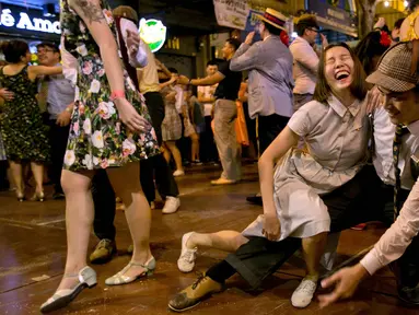Pria dan wanita menari di depan kuil Phra Pathom Chedi di provinsi Nakhon Pathom, Thailand (25/2). Lebih dari 300 peserta termasuk penari asing bernari menghebohkan sebuah jalan sekitar satu jam. (AFP Photo/Thai News Pix/Krit Promsakla Na Sakolnakorn)