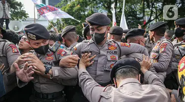 Aparat kepolisian saat terlibat saling dorong dengan massa aksi dari BEM Seluruh Indonesia (BEM SI) di kawasan Patung Kuda, Jakarta, Jumat (28/10/2022). Dalam aksinya mereka menuntut penolakan kenaikan harga BBM hingga penyelesaian pelanggaran HAM masa lalu. (Liputan6.com/Faizal Fanani)