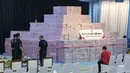 Penyerahan tahap VII ini akan disaksikan langsung Presiden Prabowo Subianto. Tampak dalam foto, para pejabat menyiapkan tumpukan uang kertas rupiah senilai sekitar 586,8 juta USD, yang disita dari berbagai kasus korupsi dan denda lingkungan, sebelum upacara penyerahan dari Kejaksaan Agung kepada pemerintah Indonesia di gedung Kejaksaan Agung di Jakarta pada Rabu 13 Mei 2026. (BAY ISMOYO/AFP)