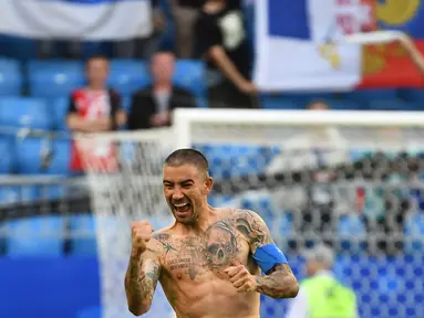 Bek Serbia, Aleksandar Kolarov dengan badan penuh tato merayakan kemenangan timnya di pertandingan sepak bola Grup E Piala Dunia 2018 Rusia di Samara, (17/6). Aleksandar memilih tato ikan koi di bagian lengannya. (AFP PHOTO / Emmanuel Dunand)