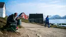Seorang pria duduk sambil mengisap pipa di Desa Kulusuk, Kota Sermersooq, Greenland, Denmark, 21 Agustus 2019. Keingingan Presiden AS Donald Trump untuk membeli Greenland ditolak pemerintah setempat. (Jonathan NACKSTRAND/AFP)